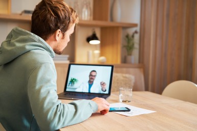 Patient zu Hause bei einer Videosprechstunde mit einem Arzt.